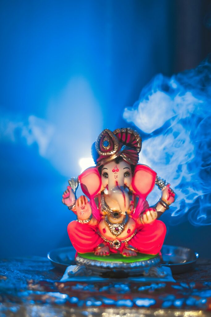 Traditional Ganesha statue with backlit smoke in a spiritual setting, Nanded, India.